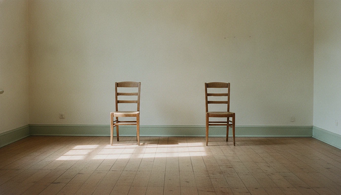 Two plain chairs facing each other in an otherwise empty room with soft window light between them.